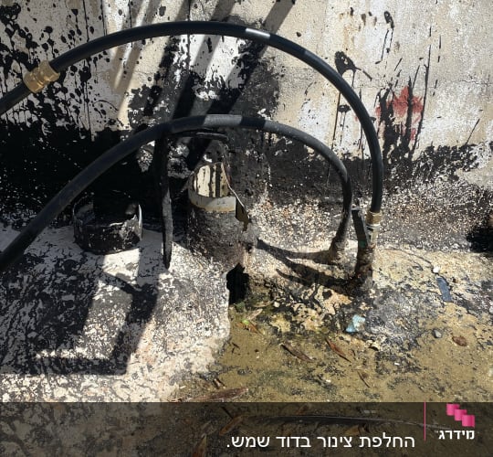 צינורות שחורים עם חיבורים על קיר מלוכלך